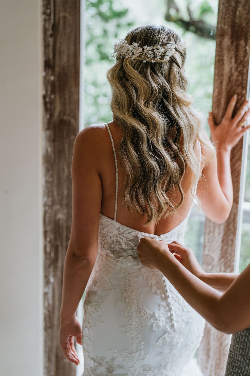 Elegant lace wedding dress details captured in natural window light.