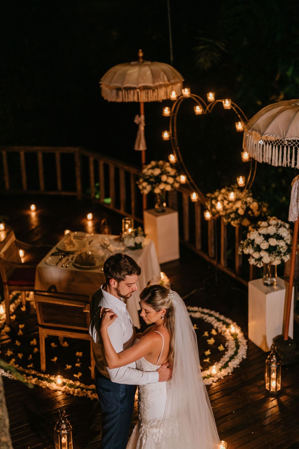 A wedding ceremony setup with decorative white umbrellas and string lights creating a magical atmosphere.