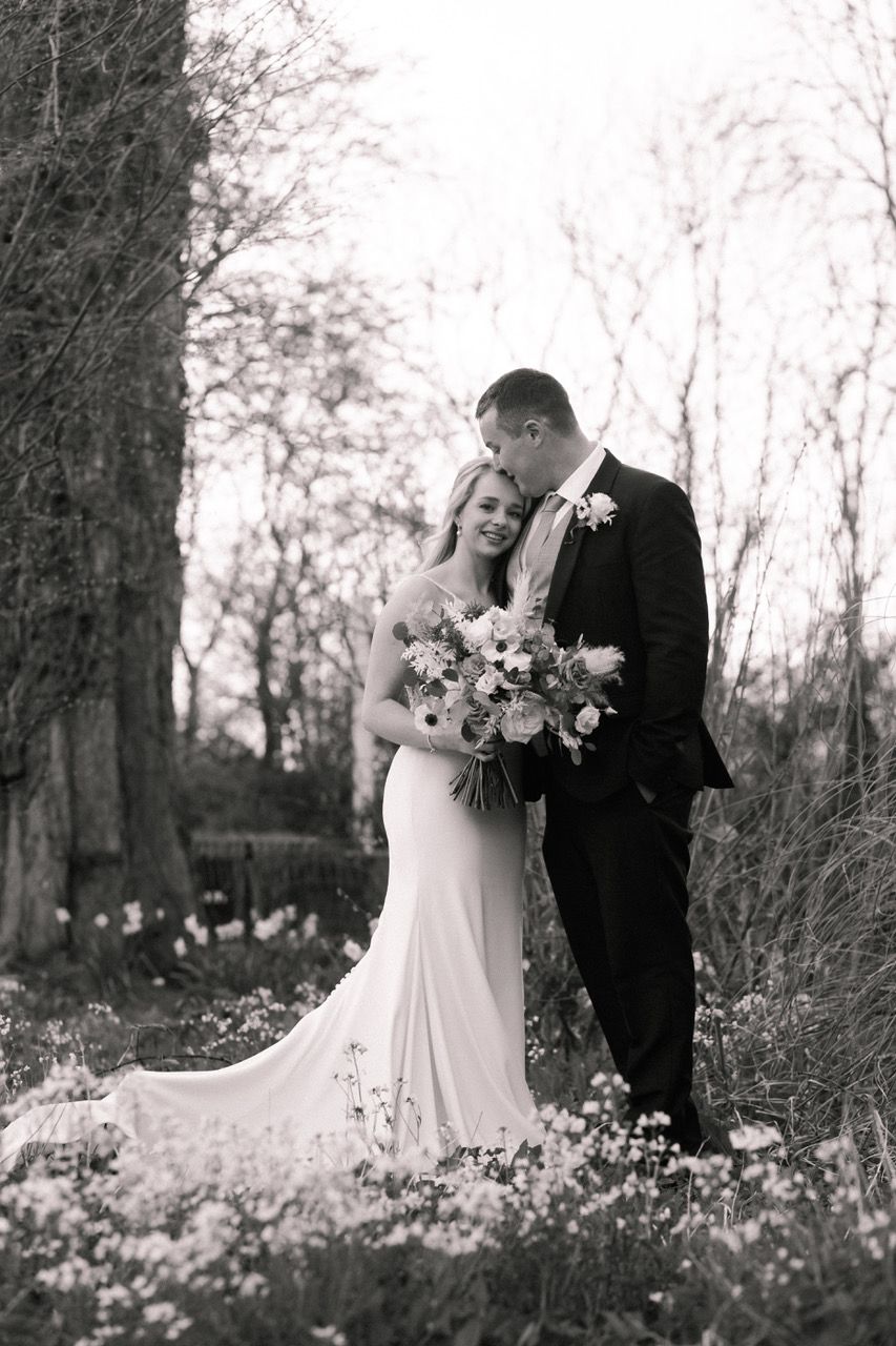 Black and white wedding portraits captured in a dreamy wildflower field.