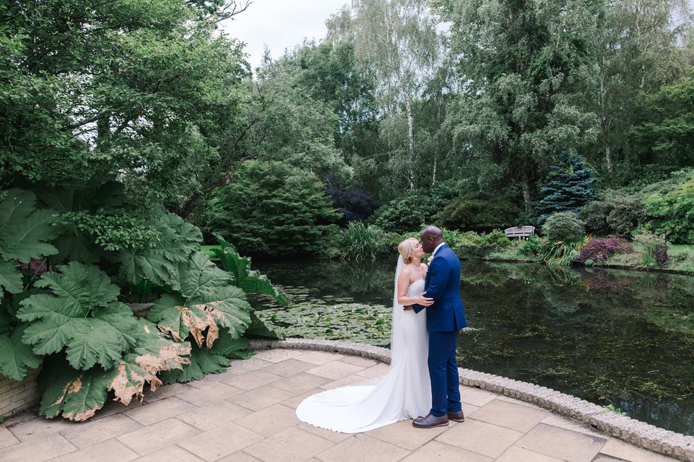 Scenic wedding photography location with a tranquil pond and natural landscaping.