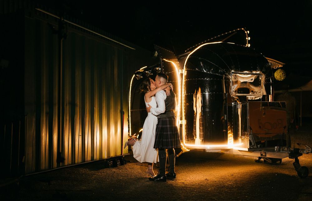 A series of dramatic nighttime wedding photos captured in front of illuminated industrial metal walls.