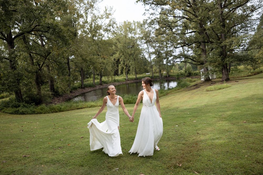 People in white dresses walking through a scenic outdoor park setting.