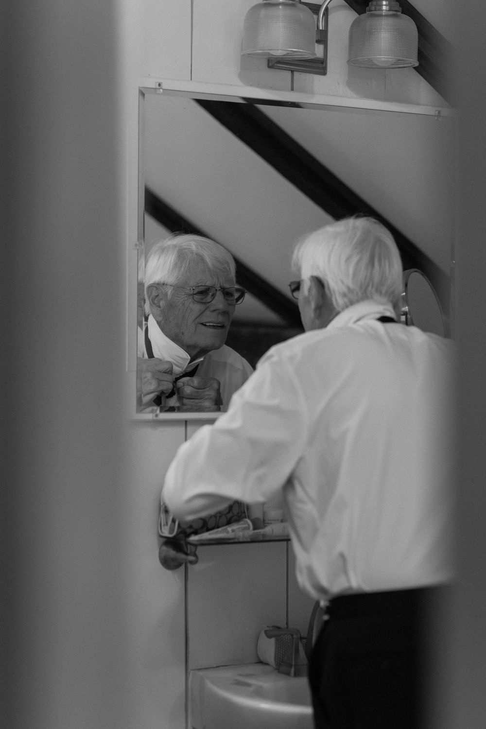 Black and white photo sequence showing someone getting ready in front of a mirror.
