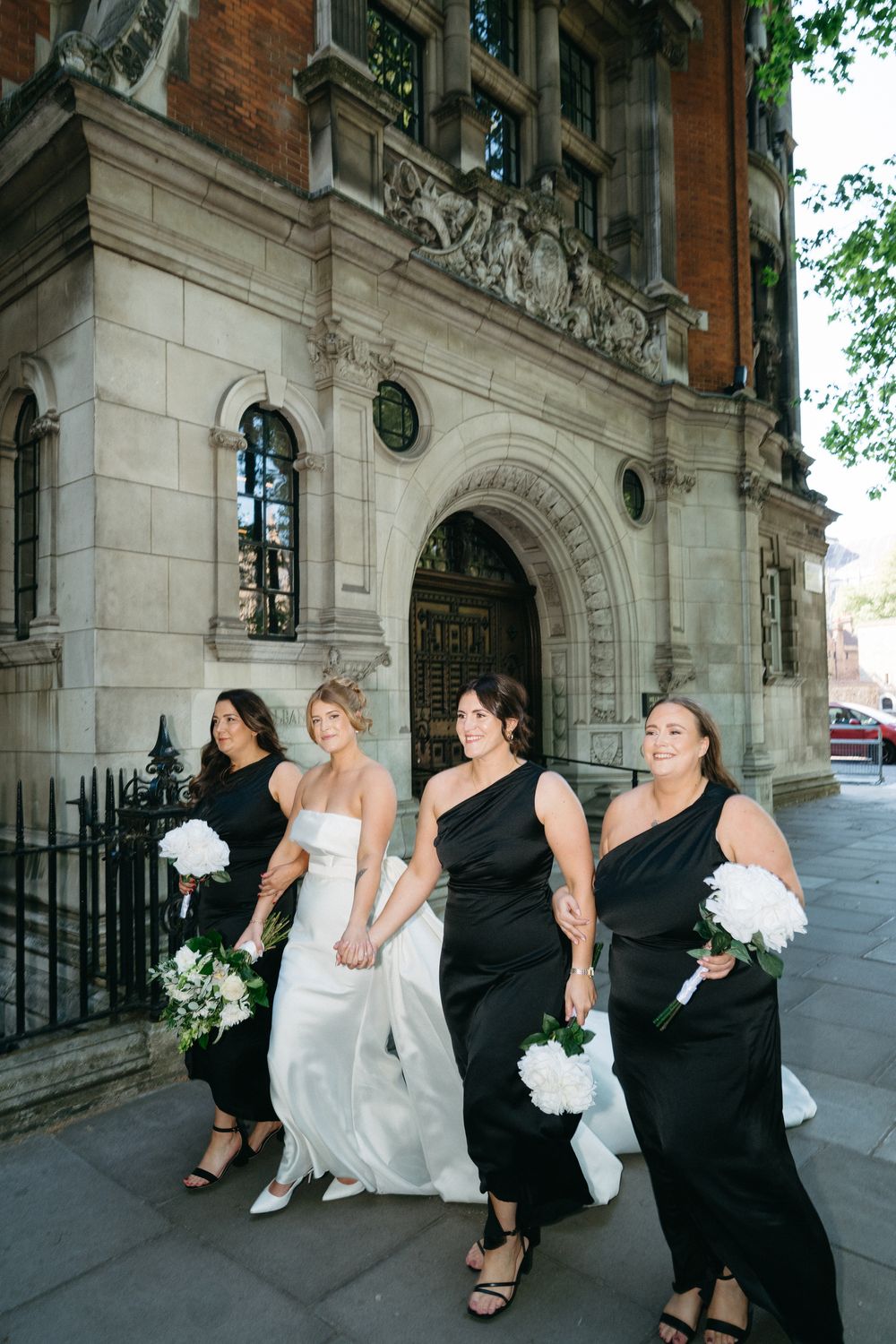 A synchronized photo sequence shows bridesmaids and a bride playfully posing together outside a historic brick building.