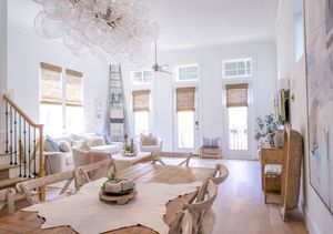 A minimalist interior design space shown in a panoramic view with white walls, natural light, and construction materials.