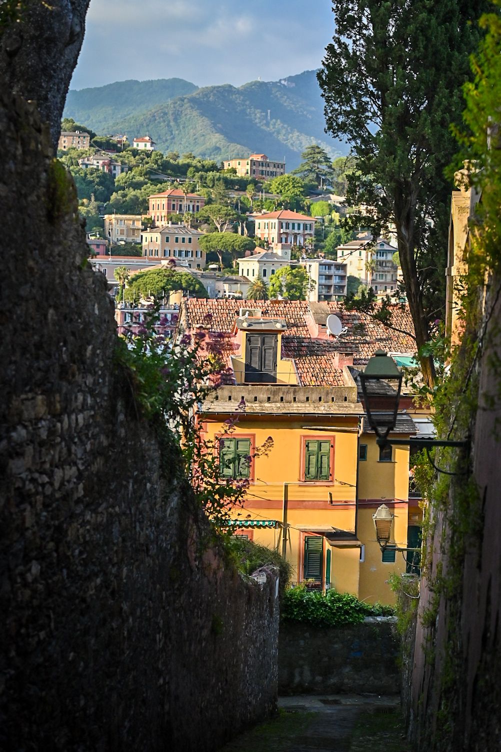 Scenic view of colorful Italian coastal buildings nestled in the mountains of Liguria with terracotta rooftops.