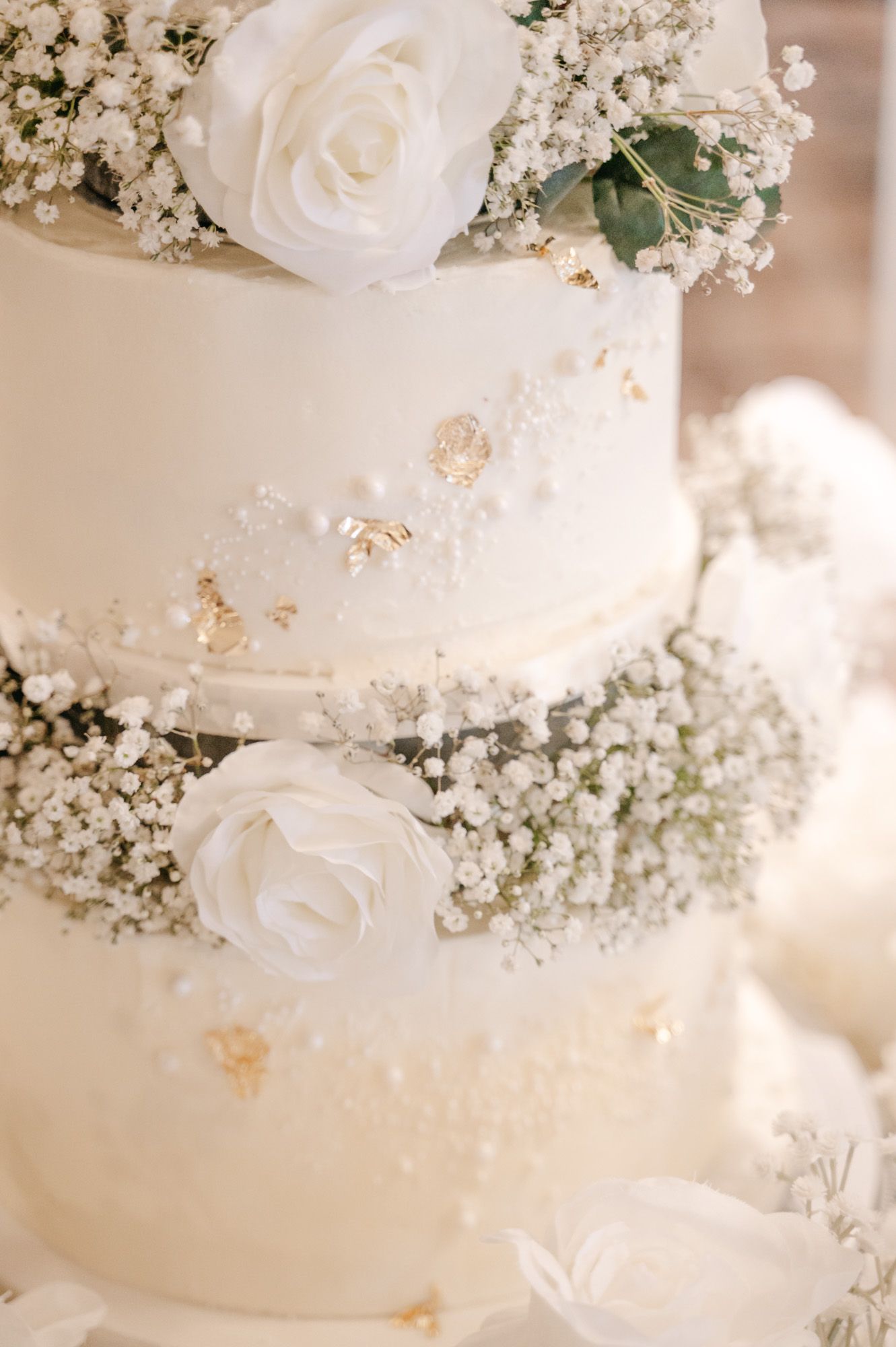 White wedding cake adorned with delicate roses and baby's breath flowers.
