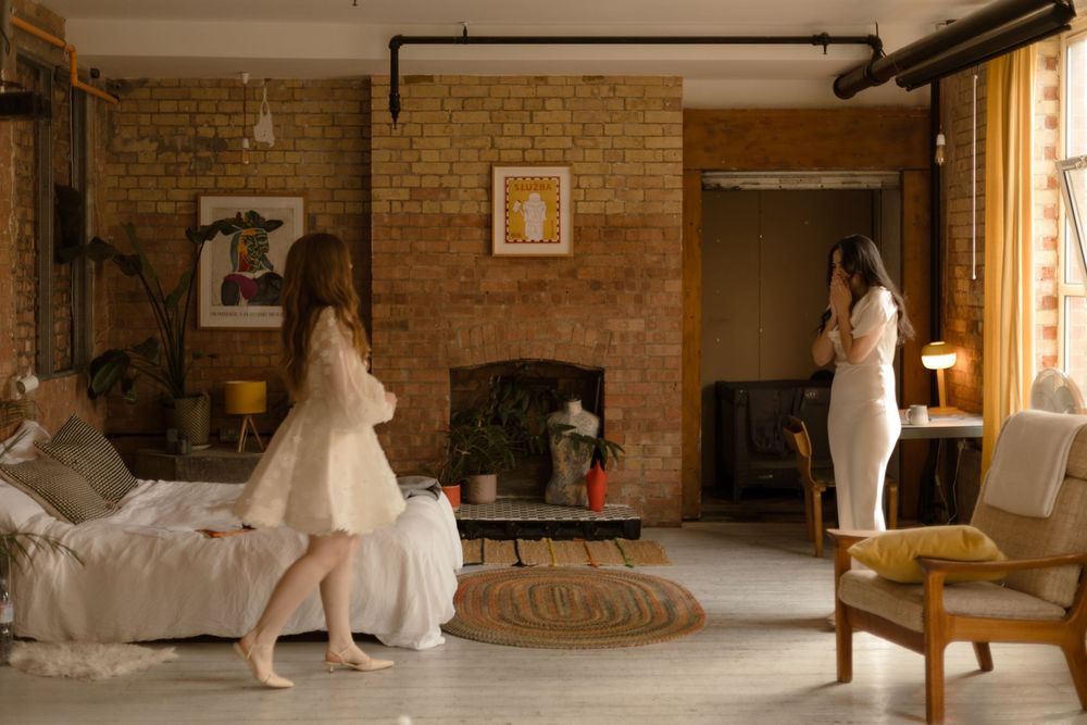 A wedding dress gown makes an elegant statement against rustic brick walls in a panoramic studio setting.
