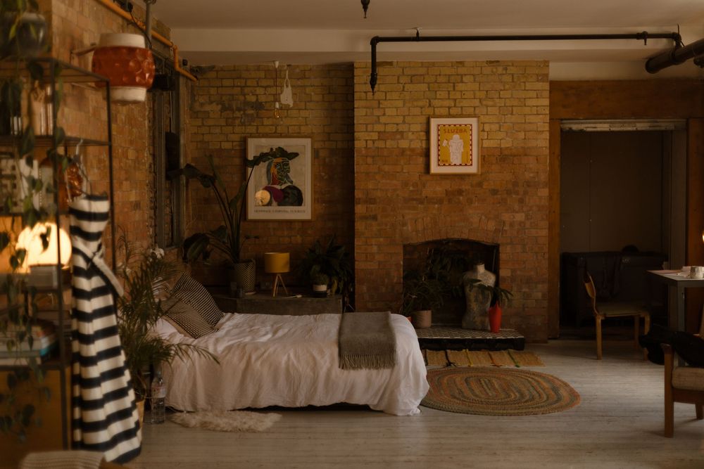 A rustic themed wedding reception venue with exposed brick walls and romantic lighting set for an evening celebration.