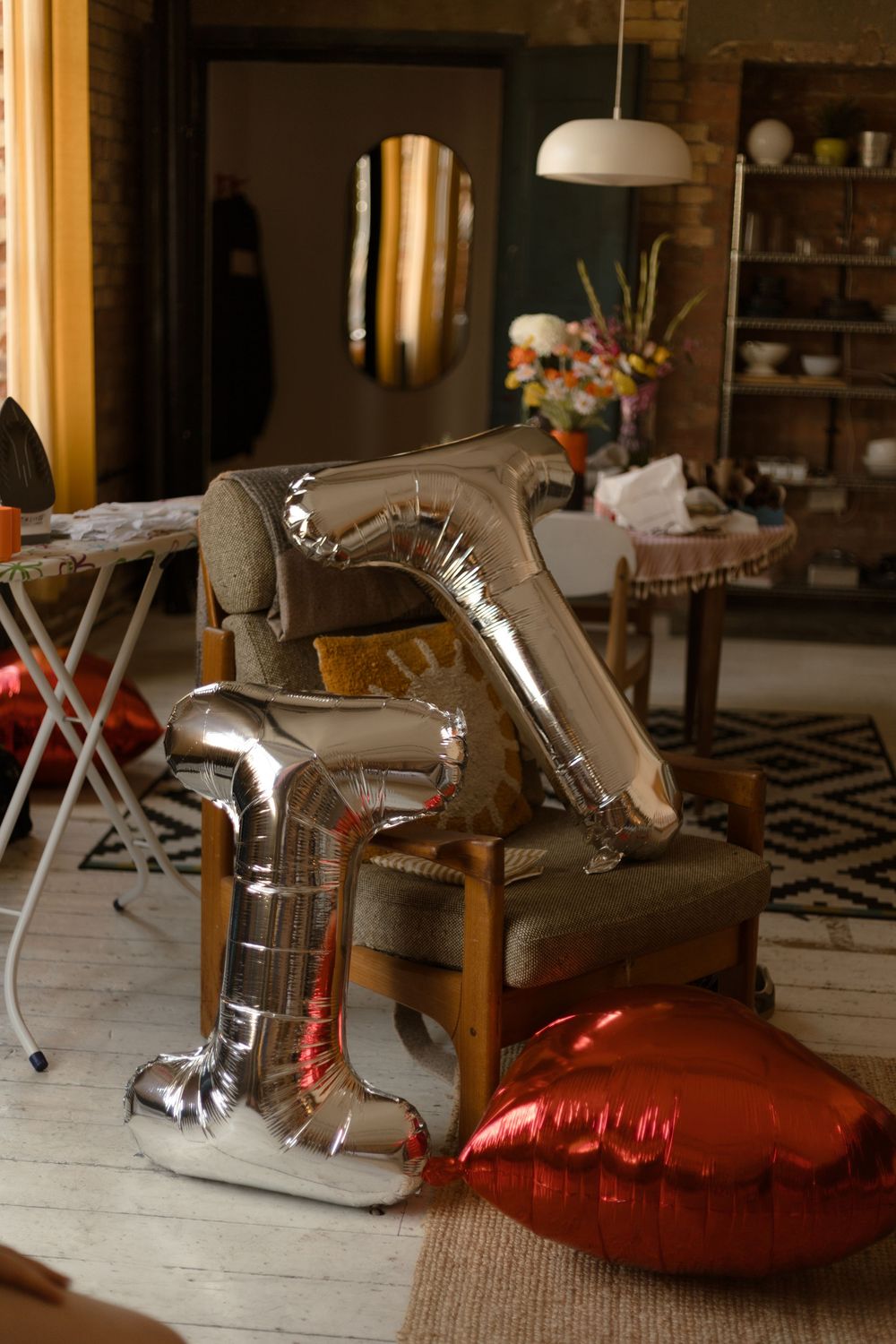 Metal robotic dinosaur toys displayed on red cushions in an indoor setting with warm lighting and wooden floors.