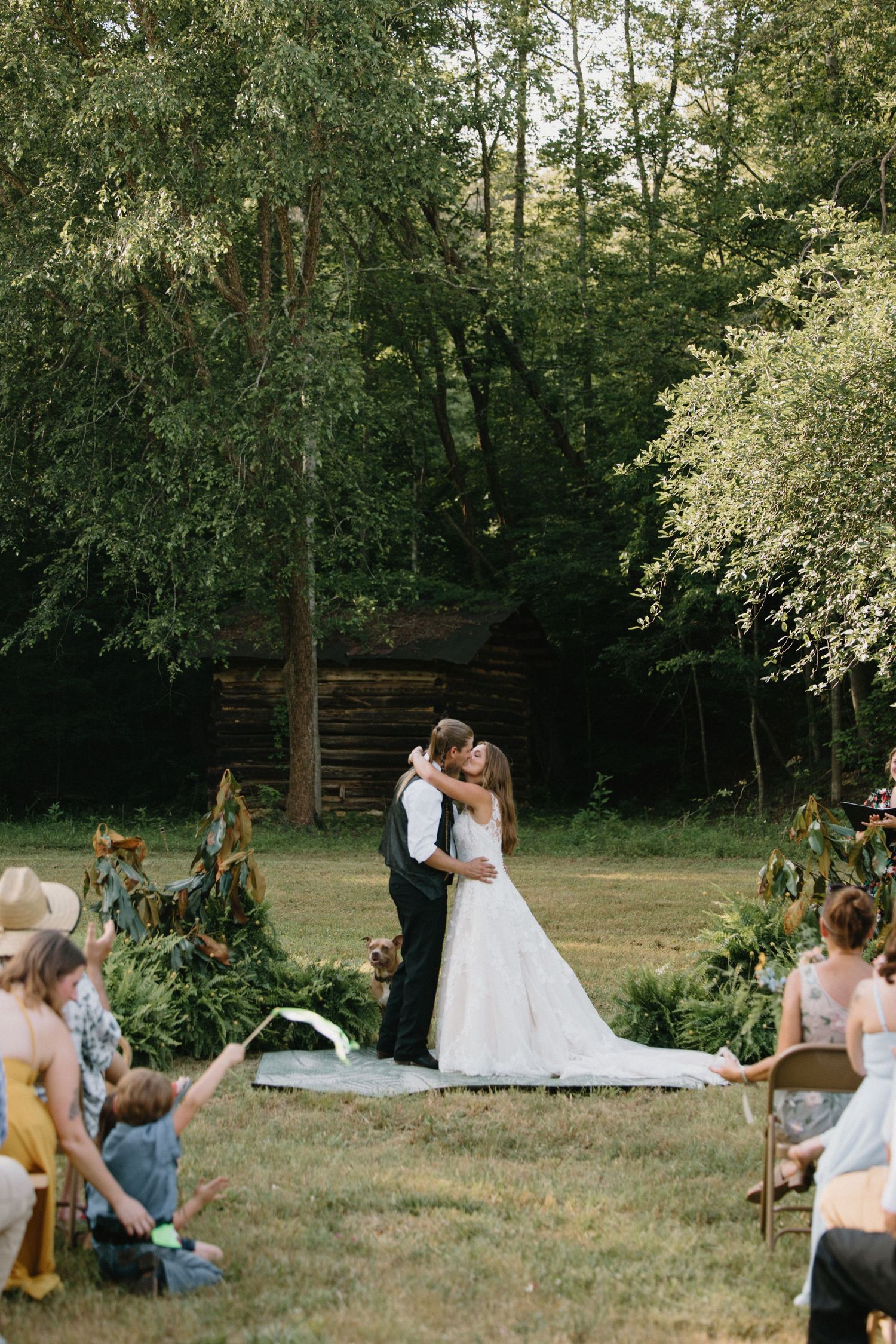 A couple celebrates their wedding in a serene outdoor garden setting surrounded by greenery and natural light.