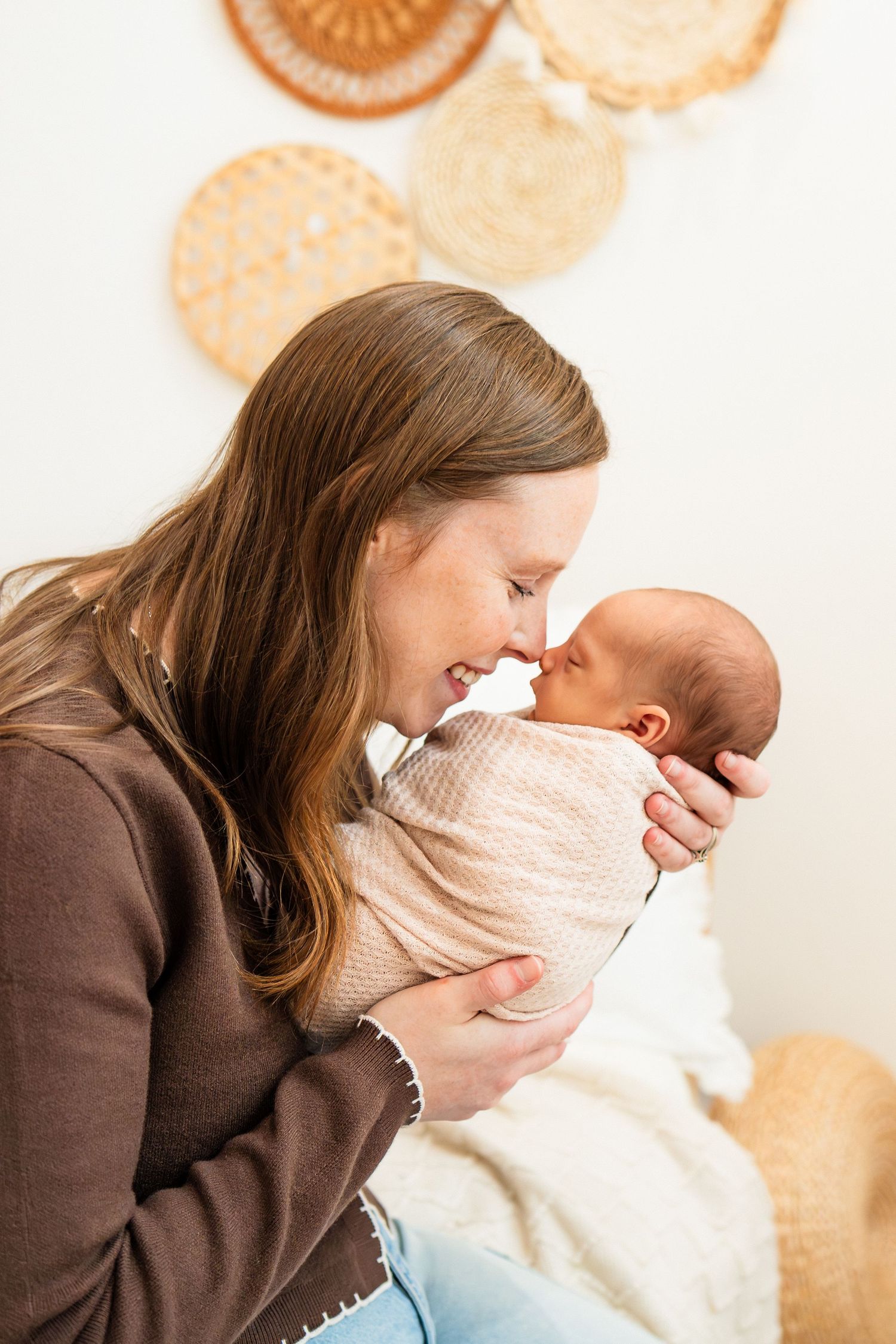 Tender moment between parent and newborn baby wrapped in soft blanket.
