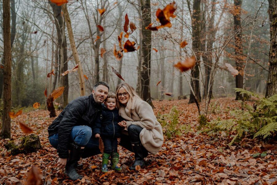 People enjoying an autumn day among fallen leaves in a misty forest.