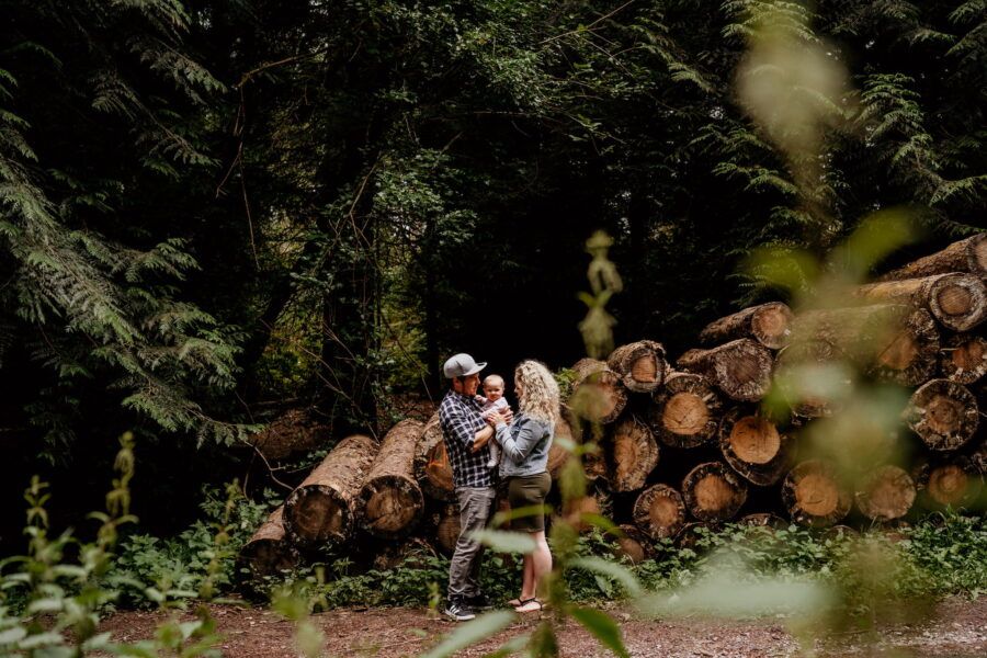 Group gathered along a rustic wooden fence in a lush forest setting.