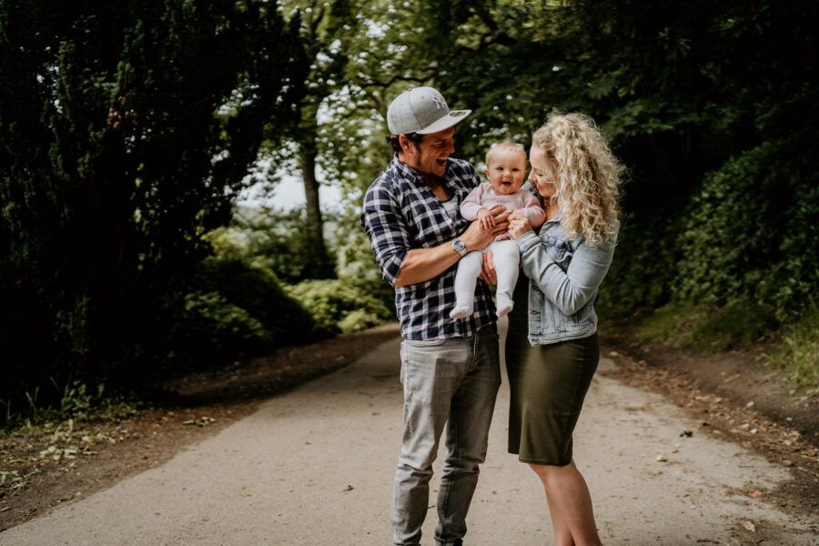 Casual family moments photographed on a winding forest trail during daytime.