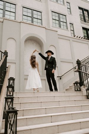 Wedding couple shares intimate moments on grand white stone staircase.