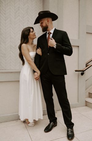 Intimate wedding portraits captured against white textured wall and steps.