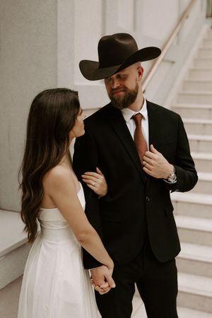 Romantic wedding sequence showing couple embracing on elegant stairs.