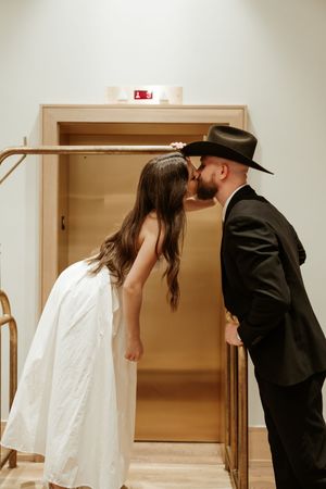 A sequence of romantic moments between a couple in formal wear near a doorway.