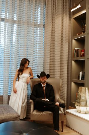 Modern room interior with venetian blinds and couple in formal attire.