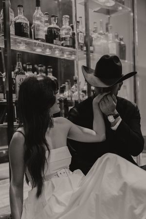 A moody black and white photo near illuminated liquor shelves.