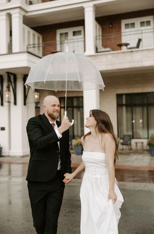A couple shares a romantic moment during their rainy wedding photoshoot.