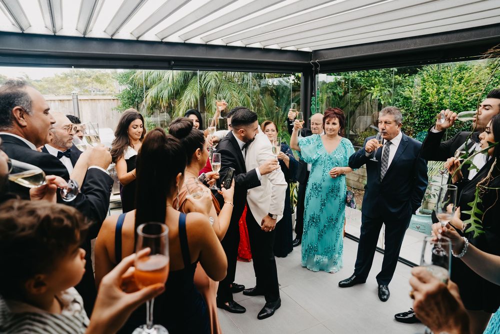 Wedding guests dance and celebrate together on the dance floor during an evening reception celebration.