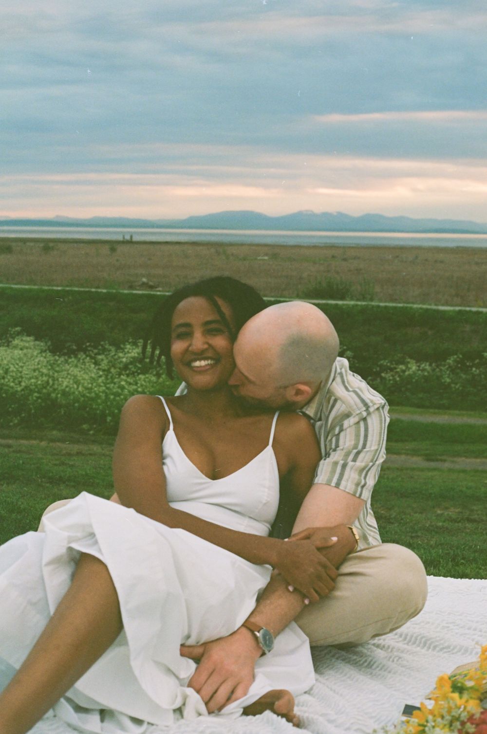 A tender moment shared between a couple during a scenic outdoor picnic.