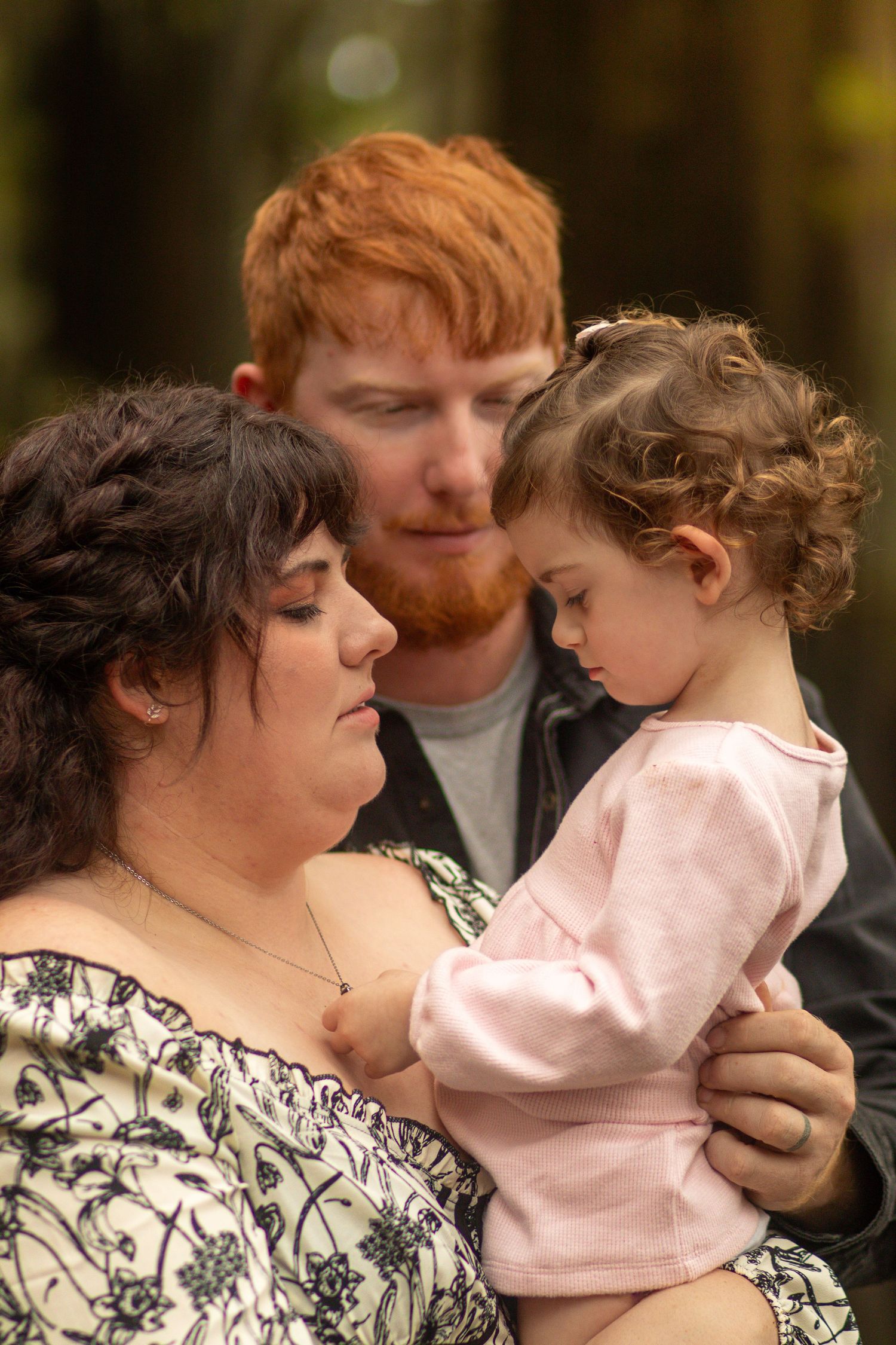 A parent in a patterned dress shares tender moments with their young child wearing pink clothing in multiple poses outdoors.