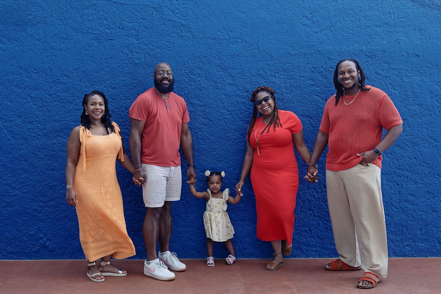 A family photo session in Playa del Carmen featuring Rachel and Sebastian Roldan with Sebastian's parents and brother under a tropical tree.