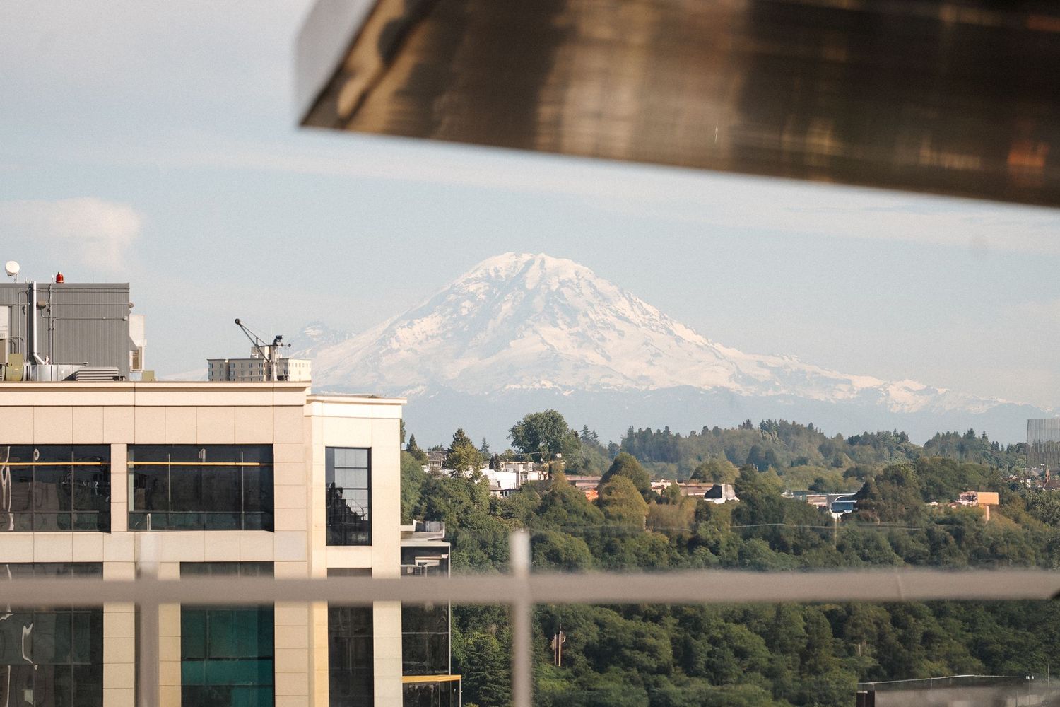Panoramic urban skyline view of Mount Rainier and tall office buildings in Seattle on a clear sunny day.