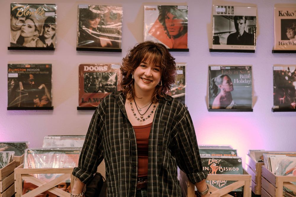 A grid of black and white and color photographs displayed on a wall with purple ambient lighting in the background.