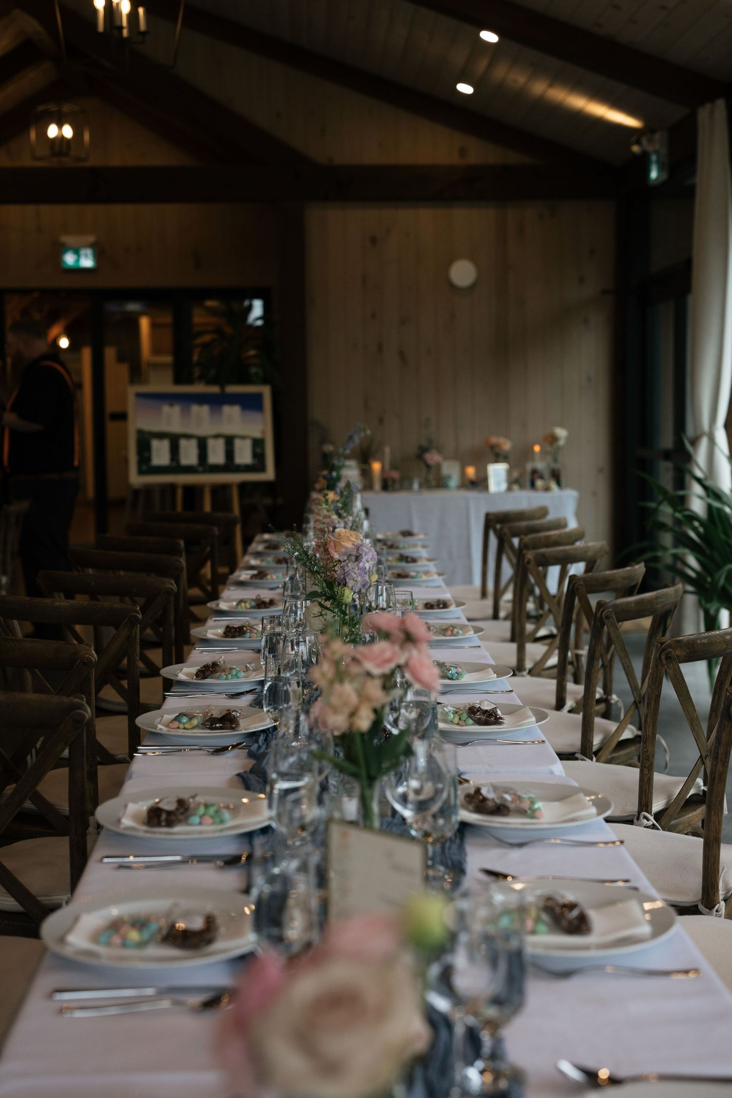 Elegant wedding table setting with white floral centerpiece and table number card.