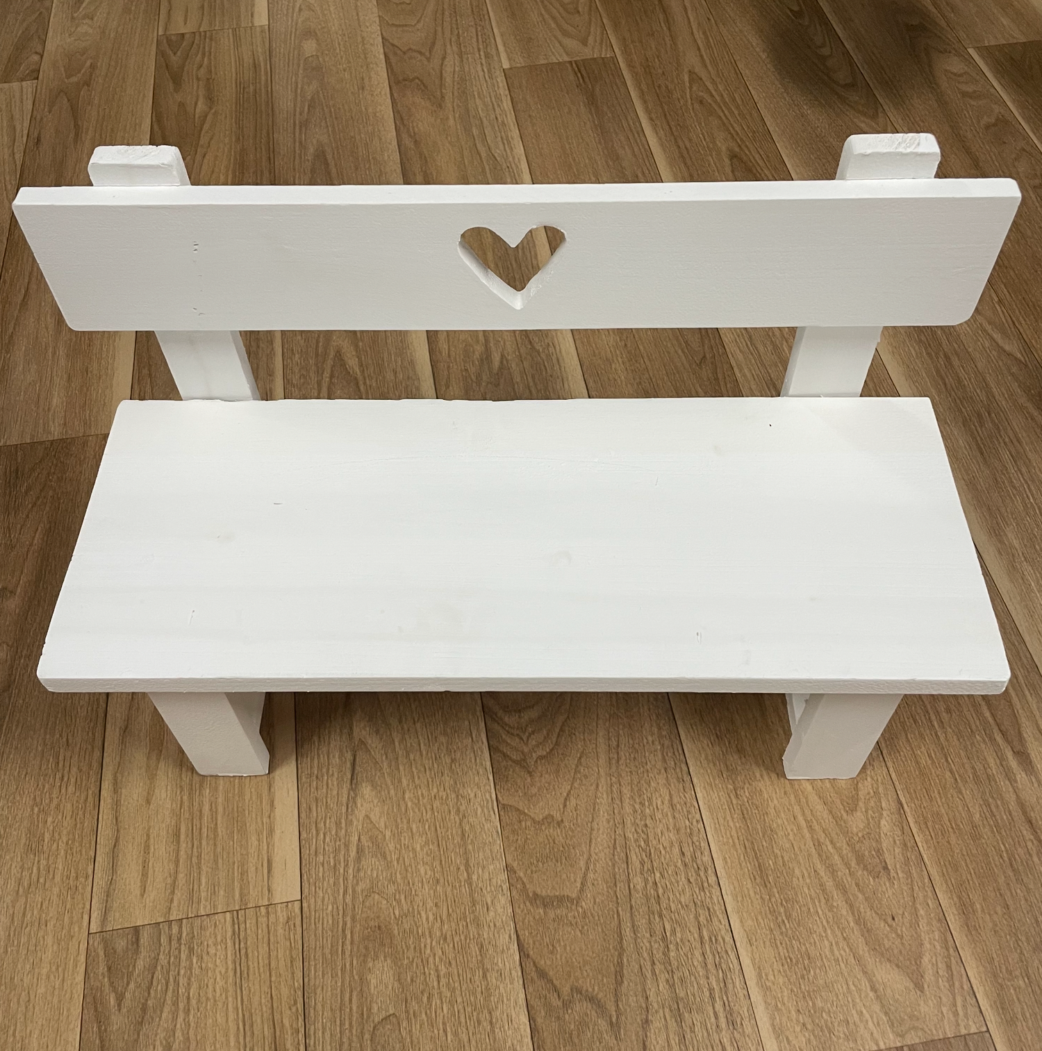 White wooden shelf with heart detail shown in progressive assembly steps.