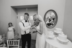 Black and white photo of a wedding couple near their wedding cake at Cleatham Hall.