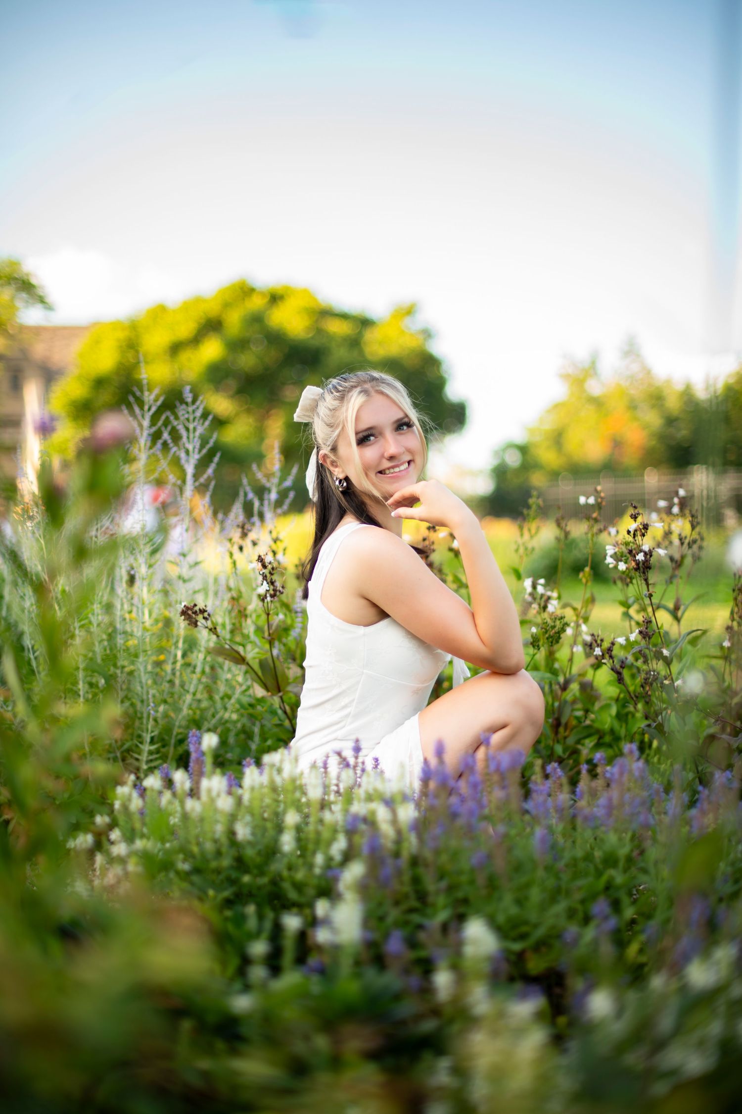 A dreamy summer portrait in a wildflower garden with purple lavender and yellow blooms in soft evening light.