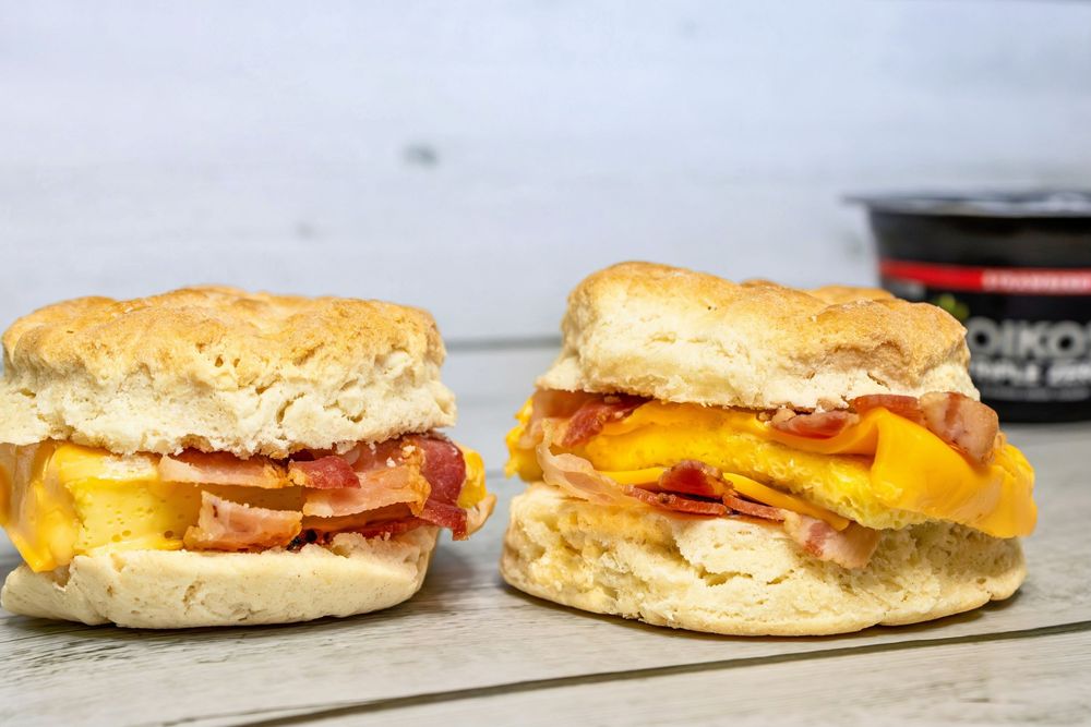 Seven sandwich images showing breakfast sandwiches with eggs, cheese, and bacon on biscuits arranged in a row.