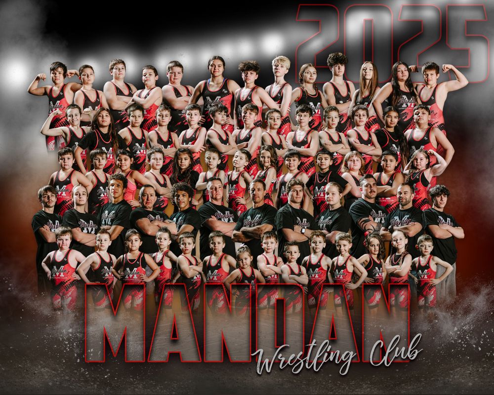 Large group team photo of a wrestling club posing together in matching red and black uniforms with dramatic lighting.