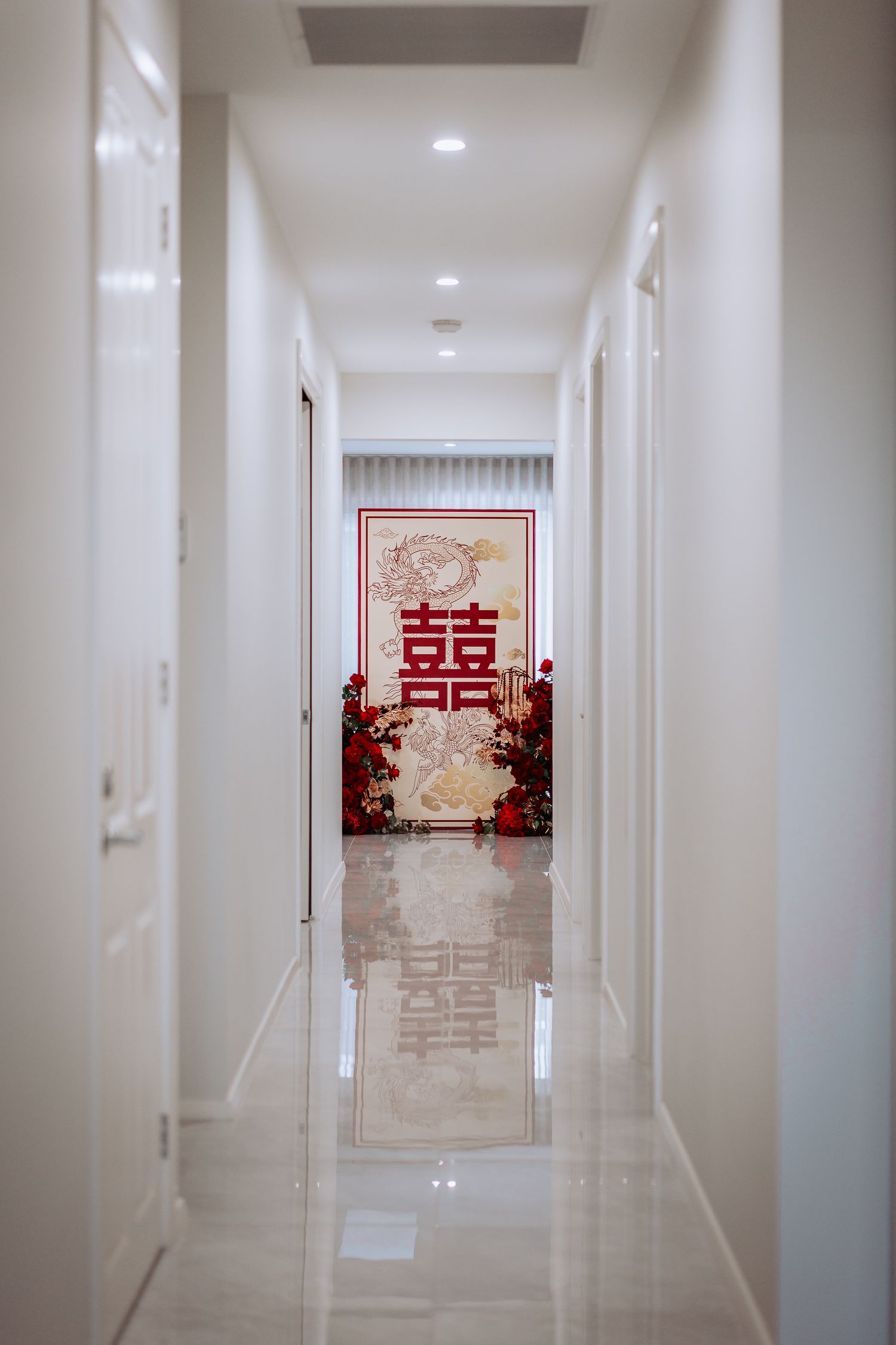 Long white hallway leads to a traditional Chinese double happiness symbol and red decorations at the end.