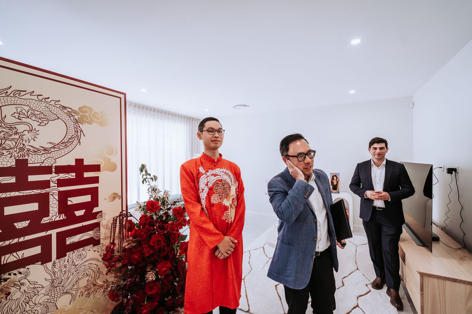 Traditional Chinese wedding decoration setup with red double happiness sign and guests in formal attire.
