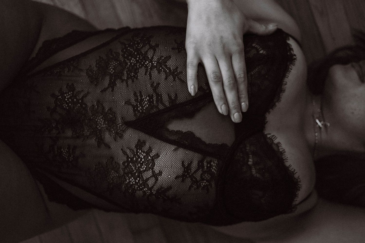 Close-up black and white boudoir detail shot, highlighting lace and intimate elegance.