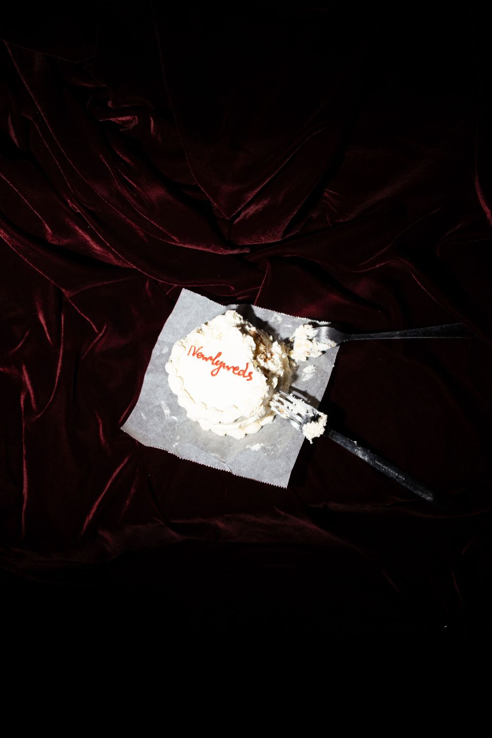 A partially crumpled piece of white paper against a dark burgundy velvet background.