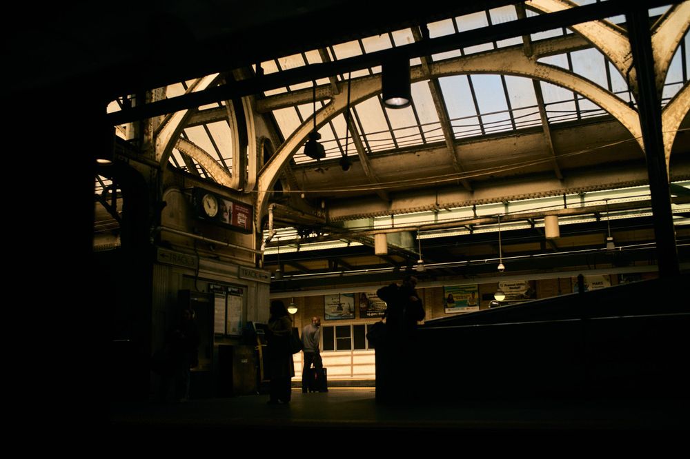 Dramatic lighting in an empty industrial space with arched ceiling and beams.
