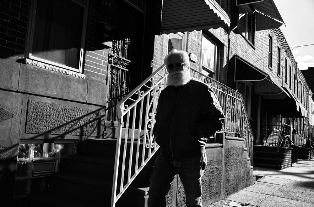 A silhouetted figure stands on urban steps in black and white street photography.