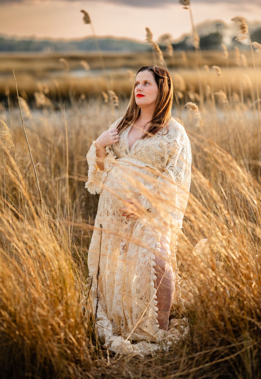 A dreamy sunset photograph shows someone wrapped in a lace shawl standing among golden wheat fields.