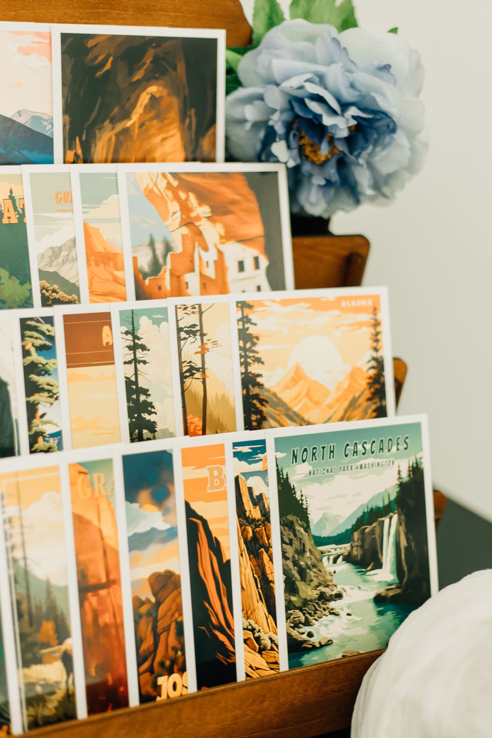 Several art prints featuring wilderness landscapes in orange and blue tones displayed in a row.