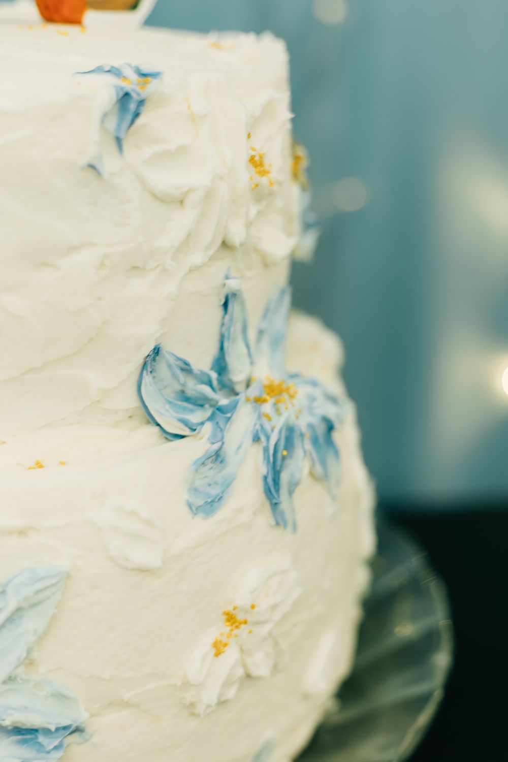 White wedding cake decorated with delicate blue floral details.