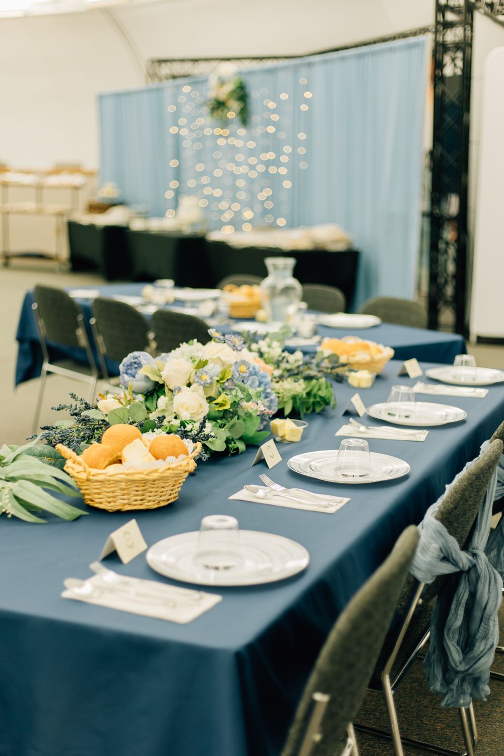 Reception tables set with navy linens and elegant place settings.