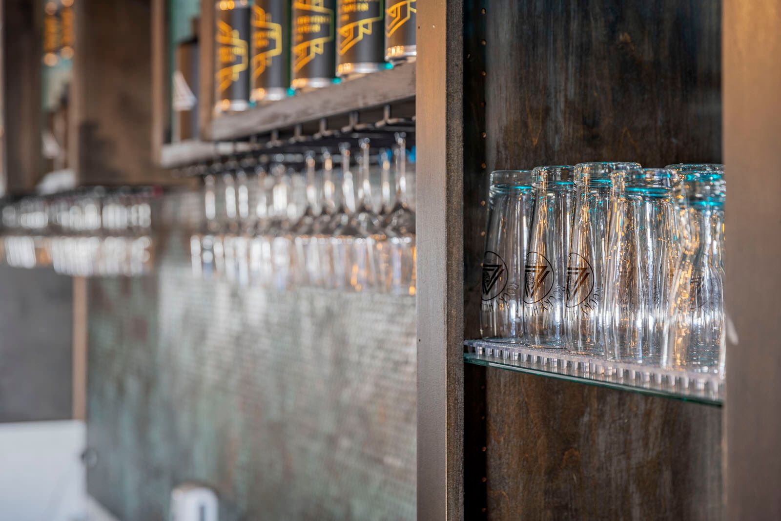Row of empty glass bottles displayed on industrial-style wall shelving.