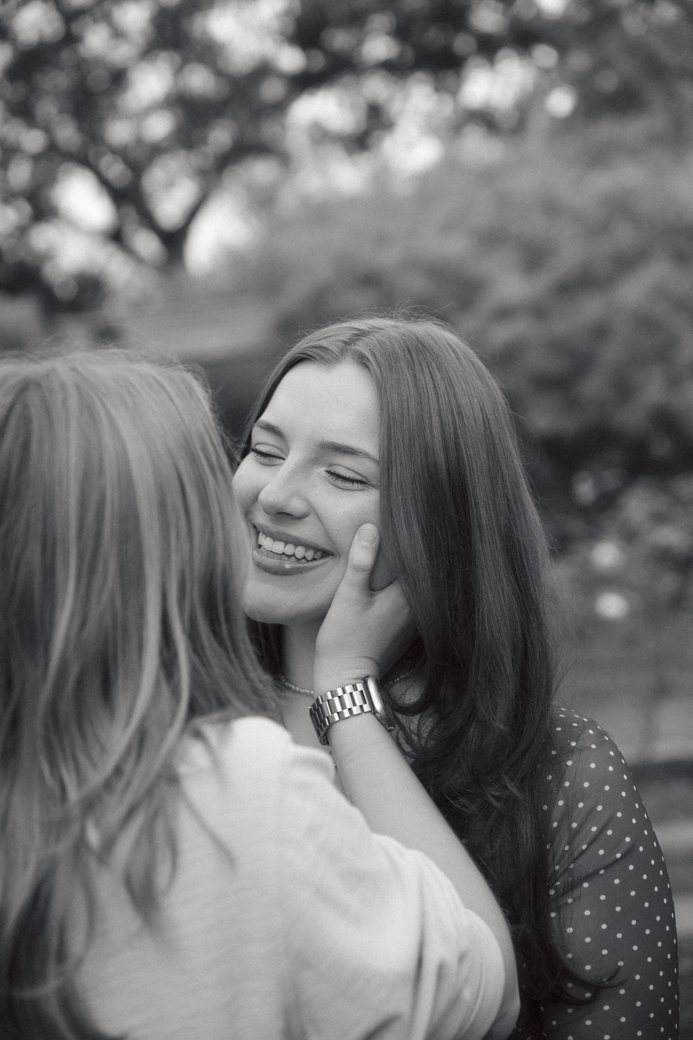 A couple shares joyful laughter and embraces in a series of black and white candid photos.
